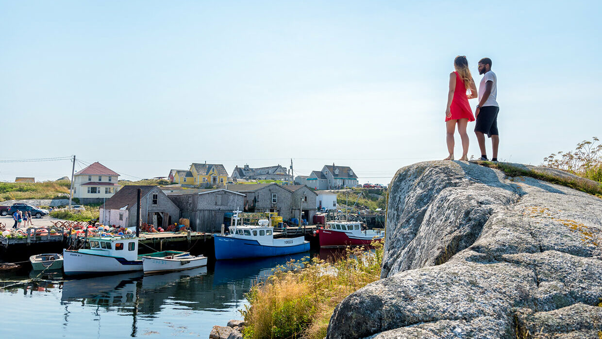 Visitors at Peggys Cove on the Rocks Overlooking the Community